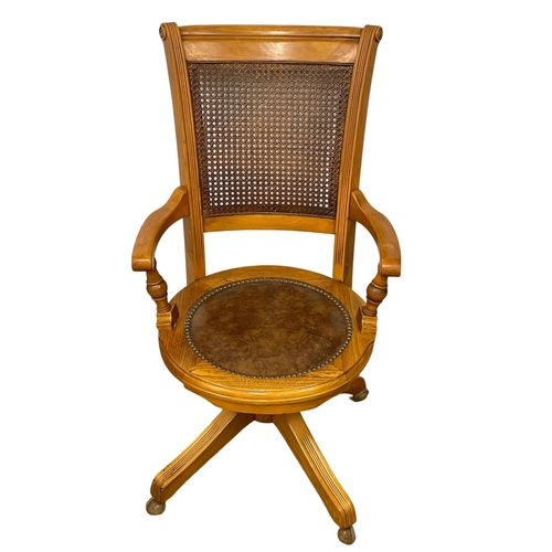 1090 - A good quality modern oak swivel desk chair, with leather seat and bergere back