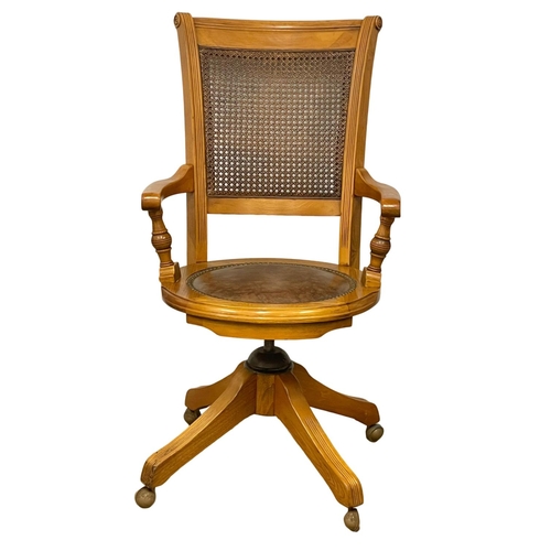 1090 - A good quality modern oak swivel desk chair, with leather seat and bergere back