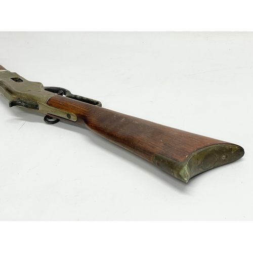 104 - A good quality replica Winchester rifle with wall mounted stand. Rifle measures 99.5cm