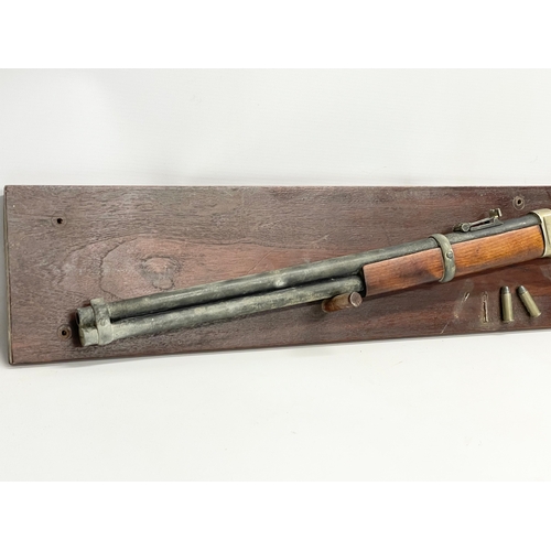 104 - A good quality replica Winchester rifle with wall mounted stand. Rifle measures 99.5cm