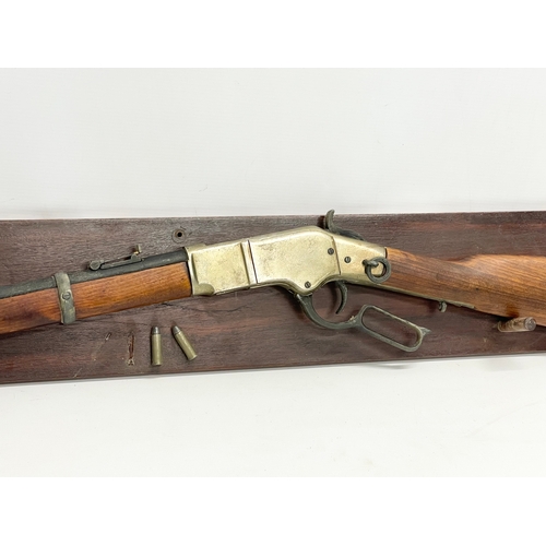 104 - A good quality replica Winchester rifle with wall mounted stand. Rifle measures 99.5cm