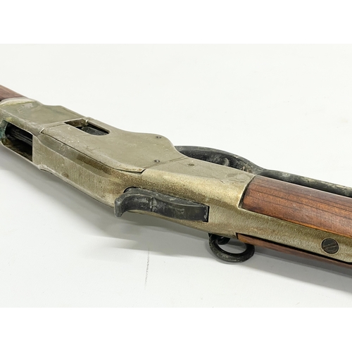 104 - A good quality replica Winchester rifle with wall mounted stand. Rifle measures 99.5cm