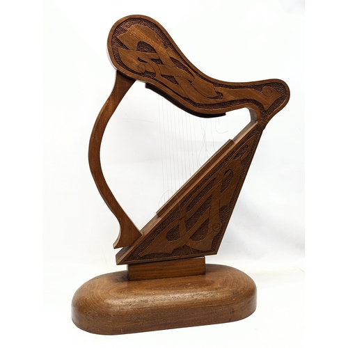 130 - A large carved walnut ornamental harp with Celtic engraving. 75.5x48cm