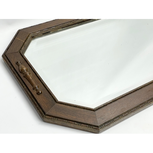 574 - A 1920’s oak frame bevelled mirror. 80x50cm