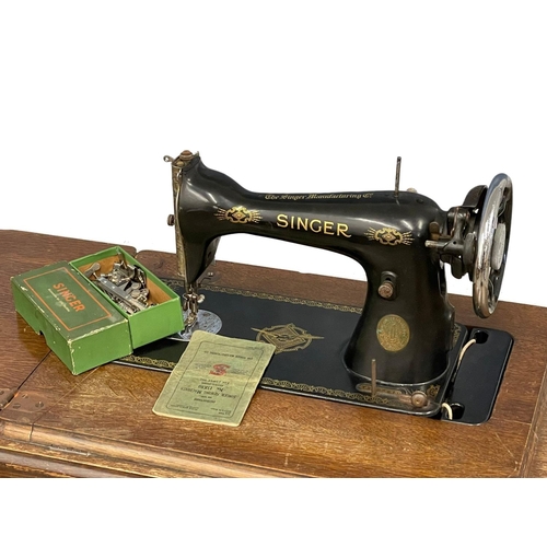 100 - A vintage oak Singer Sewing machine with accessories etc. 87x42x78cm