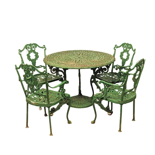 An ornate vintage metal garden table and 4 armchairs.