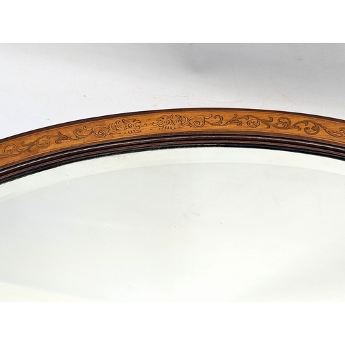 218A - An Edwardian inlaid mahogany bevelled mirror. 71x50.5cm