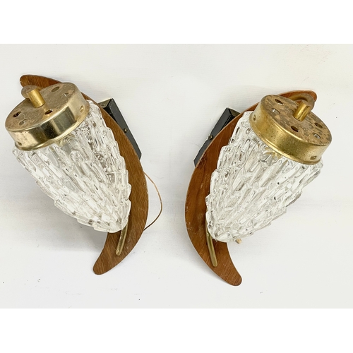 68 - A pair of Mid Century teak and brass wall lights with glass shades. 29cm