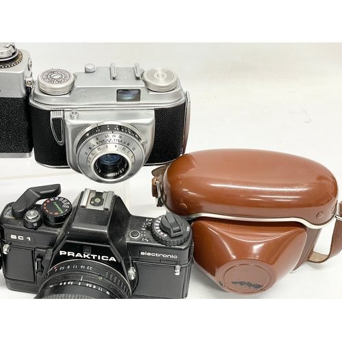 418 - 4 vintage cameras. A Praktica BC1 Electronic camera. A Rank Mamiya camera. An Exakta RTL 1000 camera... 