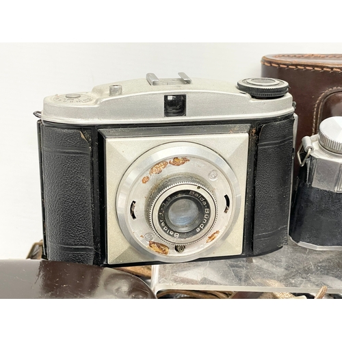 437 - A collection of vintage cameras. A Rolleiflex SL35 M camera in case. A Voigtlander Vitoret camera in... 