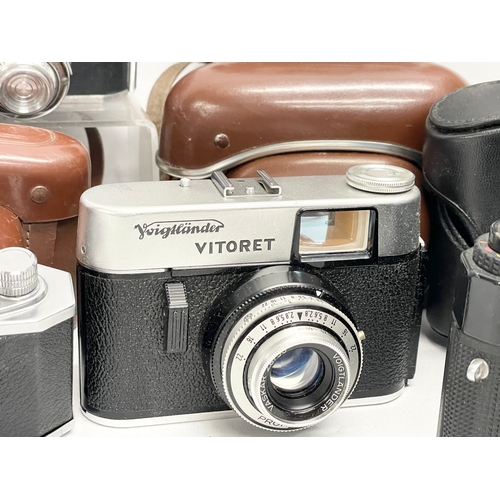 437 - A collection of vintage cameras. A Rolleiflex SL35 M camera in case. A Voigtlander Vitoret camera in... 