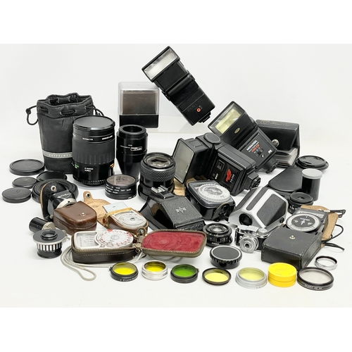 464 - A collection of camera accessories. A Mamiya 645 Prism Finder. A Pentacon Six TL Eye Level. Miranda ... 