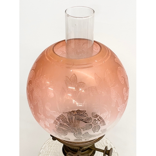 146 - A large good quality Victorian ornate brass oil lamp, with an etched Cranberry Glass shade. 80cm