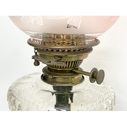 146 - A large good quality Victorian ornate brass oil lamp, with an etched Cranberry Glass shade. 80cm