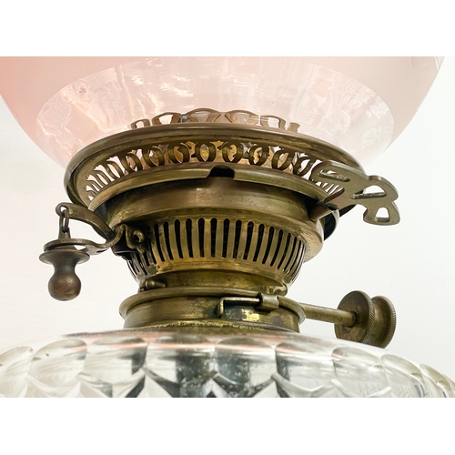 146 - A large good quality Victorian ornate brass oil lamp, with an etched Cranberry Glass shade. 80cm