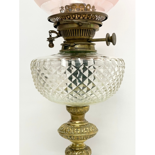 146 - A large good quality Victorian ornate brass oil lamp, with an etched Cranberry Glass shade. 80cm