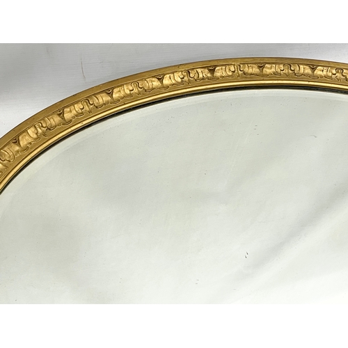 58 - An Edwardian ornate gilt framed oval mirror. 83x58cm