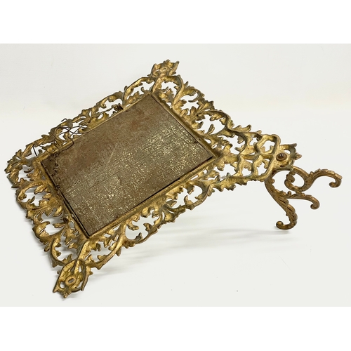 91 - A Victorian ornate brass framed bevelled mirror with hat hook. 47x53cm.