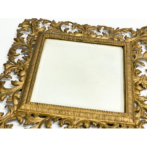 91 - A Victorian ornate brass framed bevelled mirror with hat hook. 47x53cm.