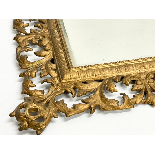 91 - A Victorian ornate brass framed bevelled mirror with hat hook. 47x53cm.