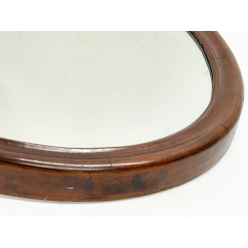 237 - A late Victorian oval mahogany framed mirror. 51x66cm