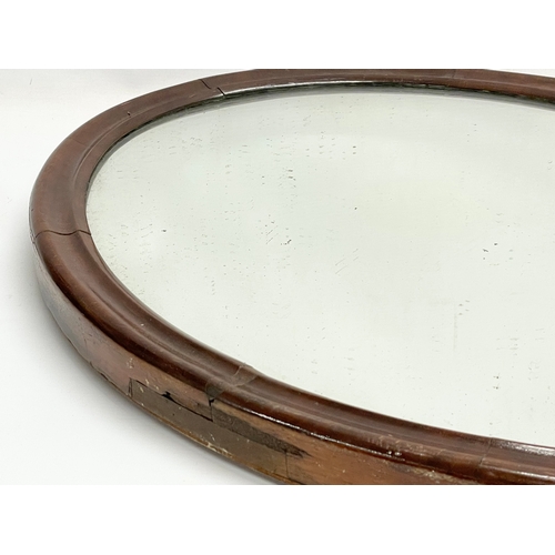 237 - A late Victorian oval mahogany framed mirror. 51x66cm