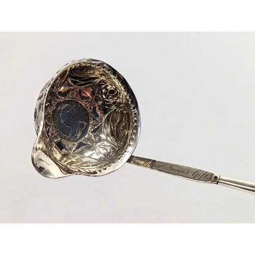 772 - A decorative silver Tottie spoon with coin image of Queen Anne with Balleen handle. 36cm