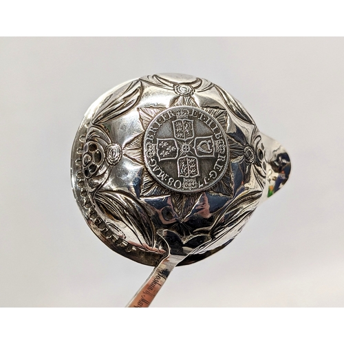 772 - A decorative silver Tottie spoon with coin image of Queen Anne with Balleen handle. 36cm