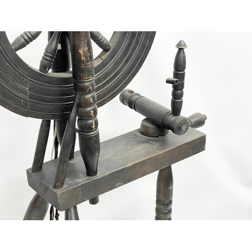 346 - A vintage spinning wheel. 108cm