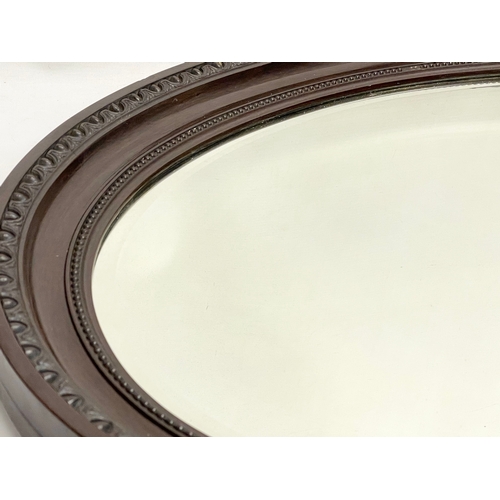 521M - An Edwardian mahogany oval mirror 87x62cm