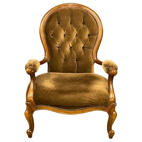 39 - A Victorian style deep button armchair on cabriole legs.