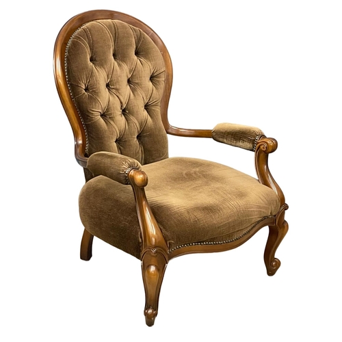 39 - A Victorian style deep button armchair on cabriole legs.