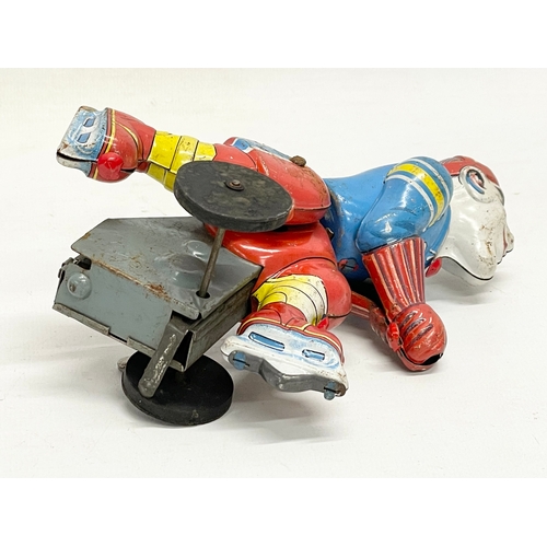 141 - A vintage Japanese tin plate windup ice skating toy. 16cm