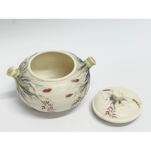 849 - A 1st period Belleek Pottery Grass Pattern sugar bowl with lid and a 2nd period Belleek Pottery jug.... 