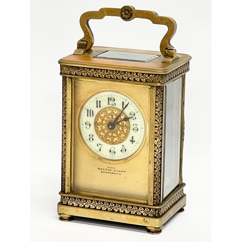 12 - A 19th century ornate brass carriage clock by Walter Wyatt. With key. 8x6x14cm including handle.