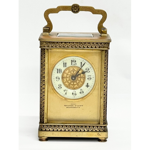 12 - A 19th century ornate brass carriage clock by Walter Wyatt. With key. 8x6x14cm including handle.