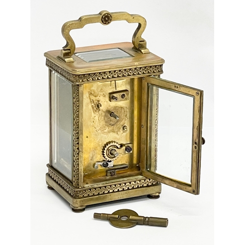 12 - A 19th century ornate brass carriage clock by Walter Wyatt. With key. 8x6x14cm including handle.