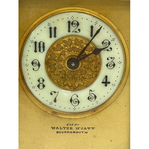 12 - A 19th century ornate brass carriage clock by Walter Wyatt. With key. 8x6x14cm including handle.