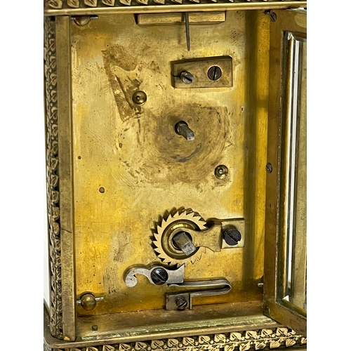 12 - A 19th century ornate brass carriage clock by Walter Wyatt. With key. 8x6x14cm including handle.