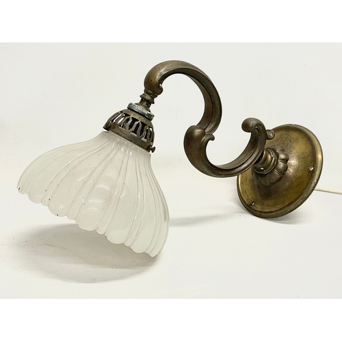 38 - A vintage brass wall lighting fitting with glass shade. 36cm