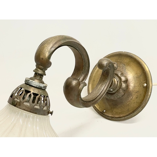 38 - A vintage brass wall lighting fitting with glass shade. 36cm