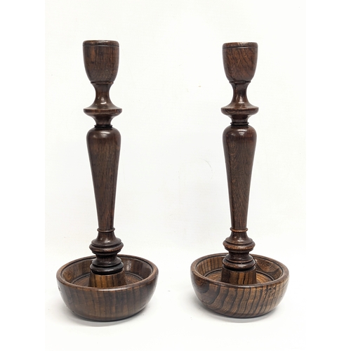 844 - A pair of early 20th century oak candlesticks. 27.5cm