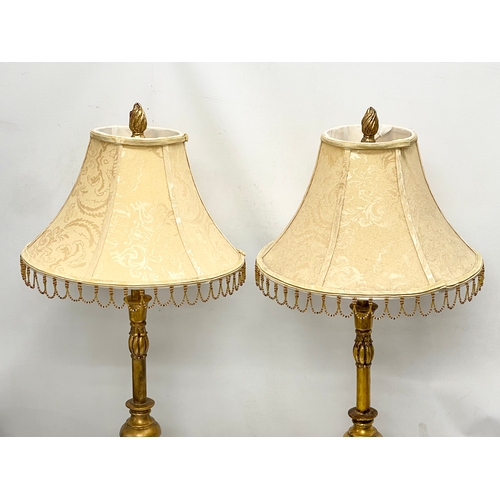 54 - A pair of tall ornate gilt table lamps. 85cm