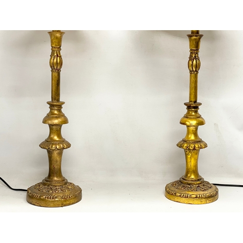 54 - A pair of tall ornate gilt table lamps. 85cm