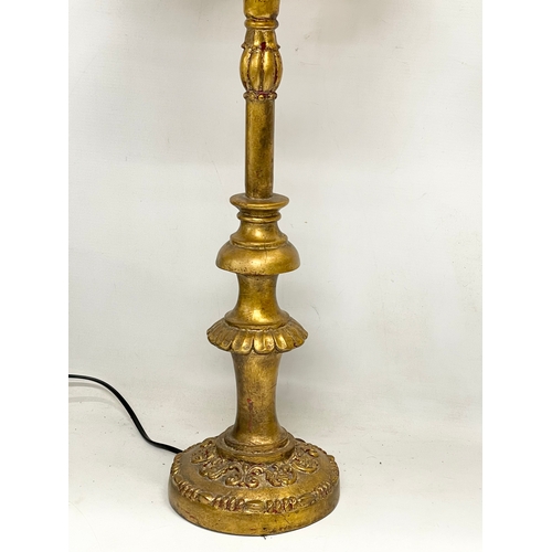 54 - A pair of tall ornate gilt table lamps. 85cm