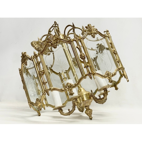 91 - A large ornate brass light fitting with etched glass panels. 46x69cm