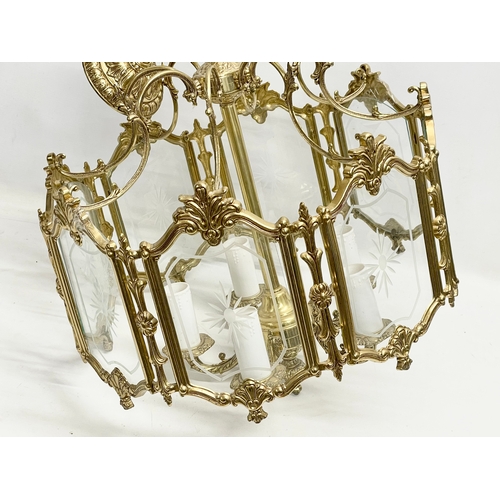 91 - A large ornate brass light fitting with etched glass panels. 46x69cm