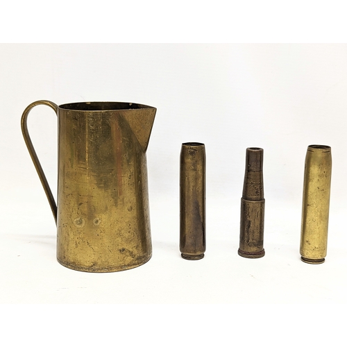 184 - A World War I German Trench Art brass jug, with 3 World War II shells, dated 1942 and 1943.