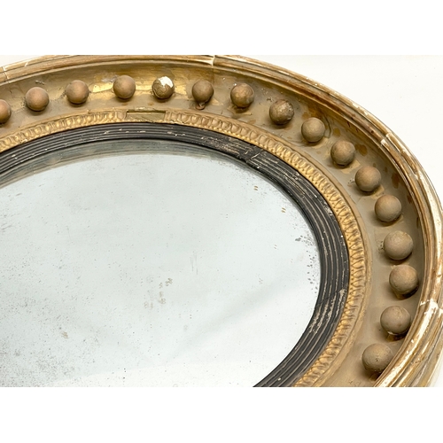 64 - A large Regency period gilt framed convex mirror. Circa 1810-1820. 59cm.