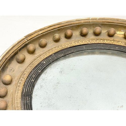 64 - A large Regency period gilt framed convex mirror. Circa 1810-1820. 59cm.